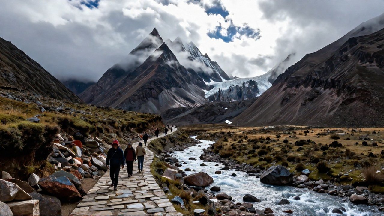 Grupo de viajeros recorre un sendero de piedra junto a un río glacial en las imponentes alturas andinas.